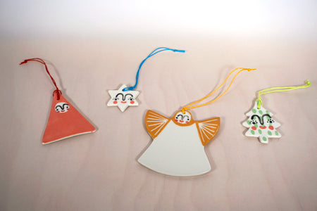 handmade ceramic christmas decorations by Beci Callow. from left to right a santa, a star, an angel and a christmas tree.