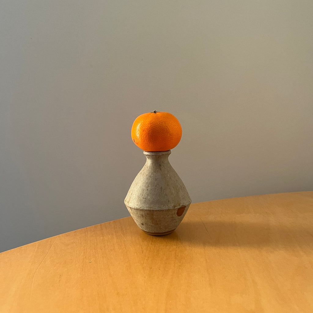 Lily Pearmain Ceramics Bellied Bud Vase with an orange on top. Photo by Holly Hay. 