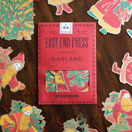 Packaged product with 'East End Press' branding surrounded by decorative paper cutouts on a wooden surface. East End Press | Shop Fodder