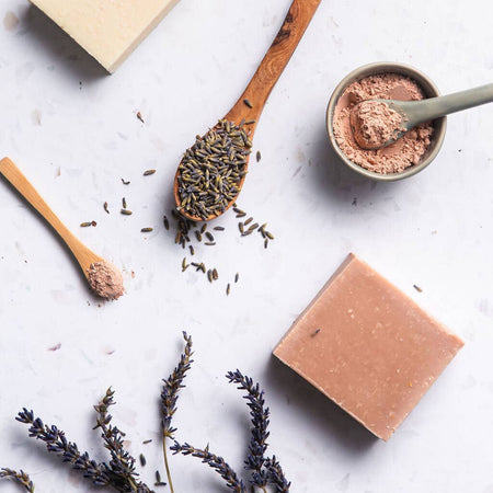 Natural soap bars, wooden spoons with dried herbs, and a small bowl on a light background |Lavender + Geranium Soap | Wild Sage & Co. | Shop Fodder