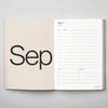 Open planner showing September layout on a grey background. 2026 Diary Red | Kinshipped |Shop Fodder