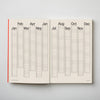 Open planner showing a yearly calendar layout on a light grey background. 2026 Planner | Kinshipped | Shop Fodder