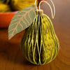 Decorative pear ornament with leaf on a wooden surface | East End Press | Shop Fodder