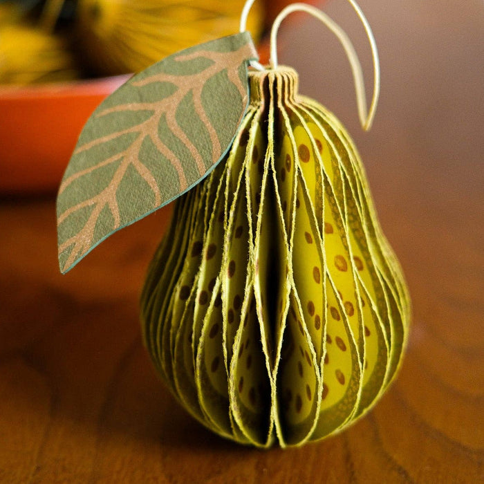 Decorative pear ornament with leaf on a wooden surface | East End Press | Shop Fodder
