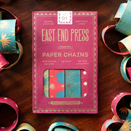 Pack of East End Press paper chains on a wooden surface with colorful paper chains around. East End Press | Shop Fodder