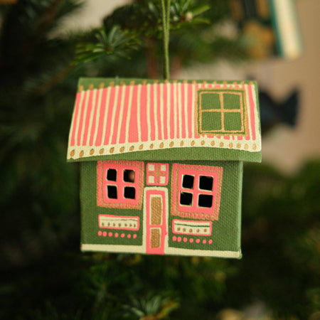 Decorative house ornament hanging on a Christmas tree. East End Press | Shop Fodder