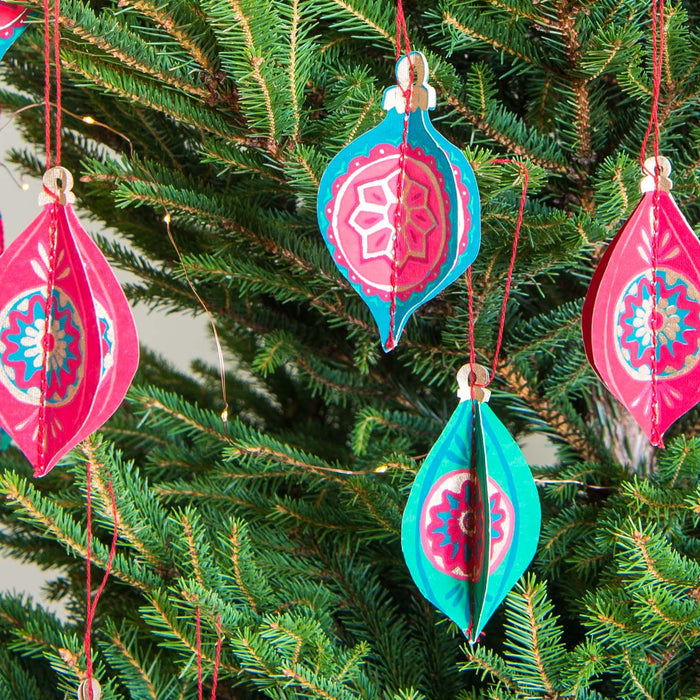 Decorative Christmas ornaments hanging on a tree. East End Press | Shop Fodder