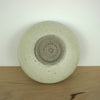 the base of a handmade ceramic incense holder showing the maker mark of Aku Ceramics. 