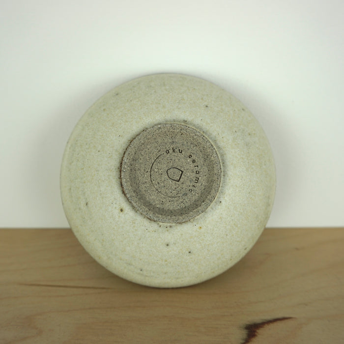 the base of a handmade ceramic incense holder showing the maker mark of Aku Ceramics. 