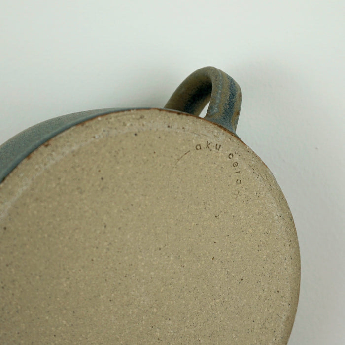close up detail of the base of a handmade mug with the makers mark of AkU Ceramics. 