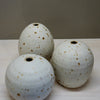 Three ceramic pots with speckled glaze on a white surface. Aku Ceramics | Shop Fodder