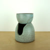 handmade oil burner sitting on a birch ply table with a white background.