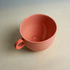 Red ceramic mug on a beige background. Syros Mug | Anna Jones Ceramics | Shop Fodder