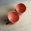 Two pink mugs with colorful handles on a light surface. Syros Mug | Anna Jones Ceramics | Shop Fodder