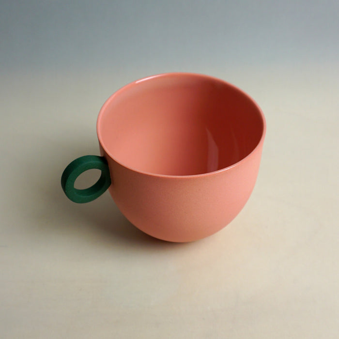 Pink cup with a green handle on a light gray background. Syros Mug | Anna Jones Ceramics | Shop Fodder