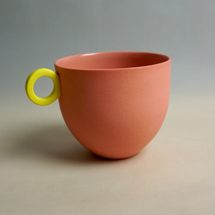 Pink cup with a yellow handle on a gray background. Syros Mug | Anna Jones Ceramics | Shop Fodder