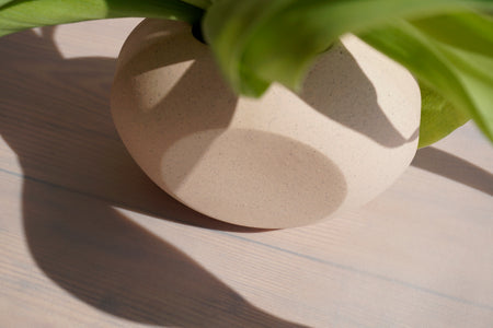 close up detail a peach ceramic vase by the maker anna jones. 