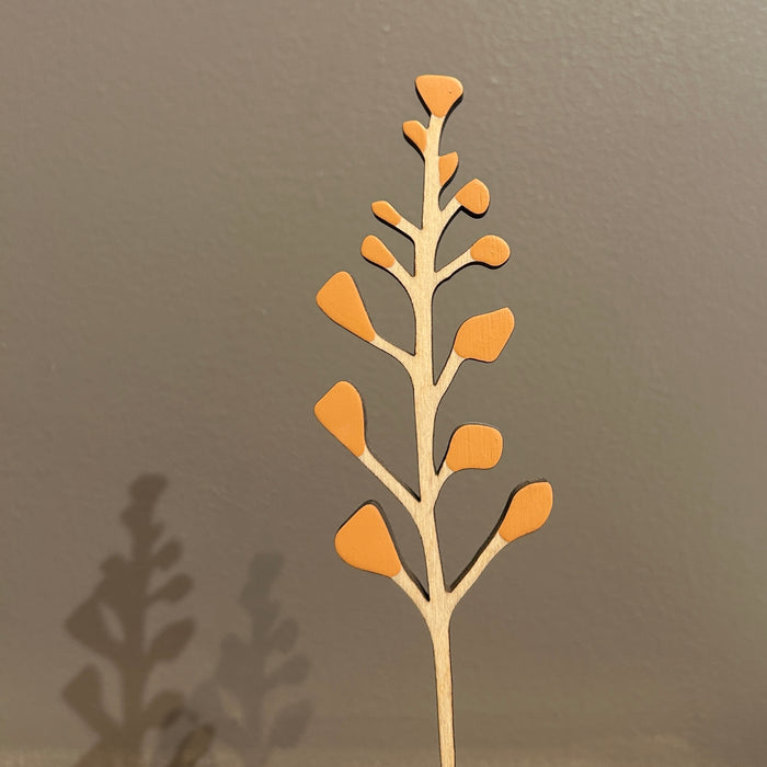 Decorative plant stem with brown leaves against a gray background. Anna Wiscombe | Shop Fodder