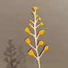 Decorative wall art of a branch with yellow leaves on a gray background. Anna Wiscombe | Shop Fodder