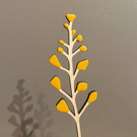 Decorative wall art of a branch with yellow leaves on a gray background. Anna Wiscombe | Shop Fodder