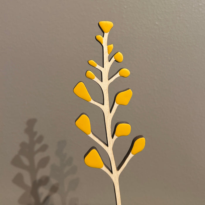 Decorative wall art of a branch with yellow leaves on a gray background. Anna Wiscombe | Shop Fodder