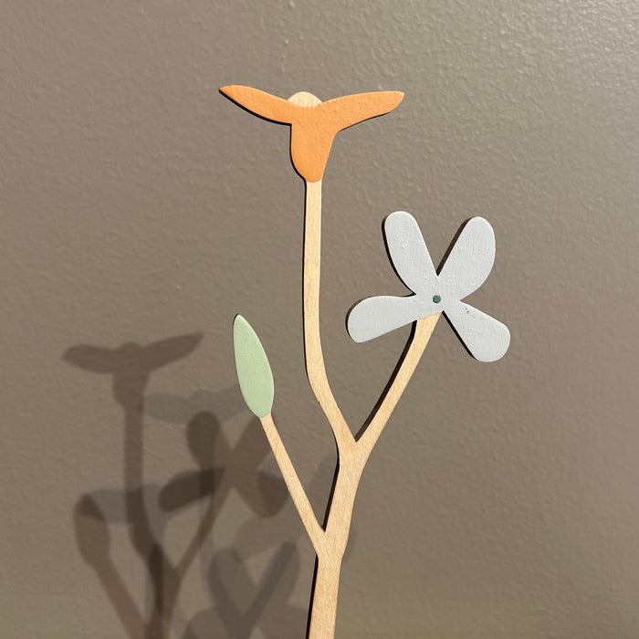 Decorative wall art with a branch, leaves, and a flower on a plain background. Anna Wiscombe | Shop Fodder
