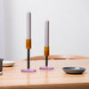 candlestick holders on a table with a jug and a dish. 
