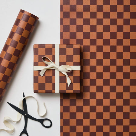 Brown and white checkered gift wrap with a wrapped gift and scissors on a white background. | Kinshipped | Shop Fodder