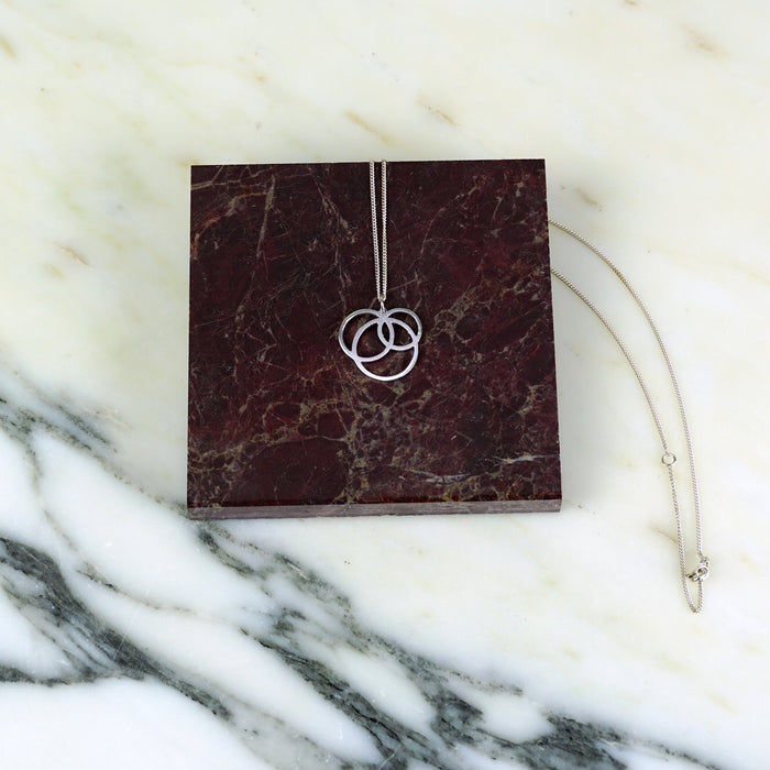 Silver necklace with a pendant on a maroon marble surface |Square_Dissarray_Pendant_Scarlett_Cohen_French_Shop_Fodder_
