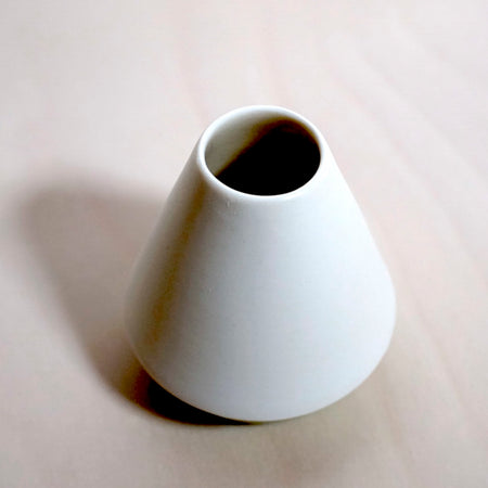 close up or a white angular candlestick holder. 
