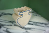 cream vase with blue outline pattern on a marble worktop