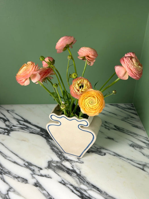 cream vase with blue outline pattern and pinky yellow flowers