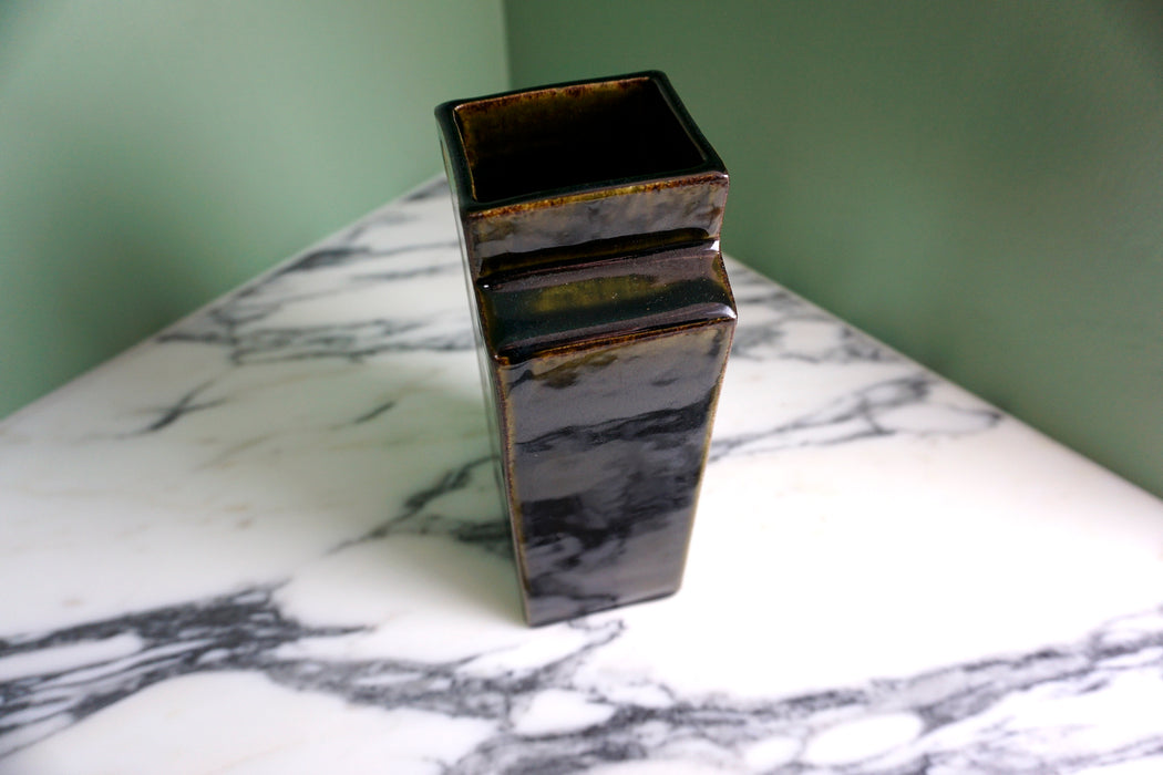 side view of a deep glossy black vase