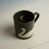 Black mug with a white swan design on a light backgroundTwo brown mugs with white swan designs on a light grey background | Fern Taylor Ceramic Nerikomi Vase | Shop Fodder