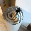 Checkered paper roll with a small checkered box on top, placed on a white surface. Fern Taylor | Shop Fodder