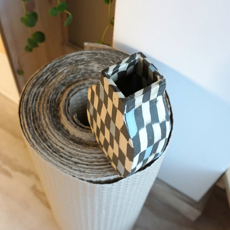 Checkered paper roll with a small checkered box on top, placed on a white surface. Fern Taylor | Shop Fodder