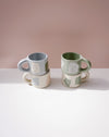 Two ceramic mugs with abstract designs on a light pink background. Portrait Mug | Brutes London | Handmade Ceramics | Fodder