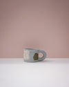Blue mug with a face design on a pink background. Portrait Mug | Brutes London | Handmade Ceramics | Fodder