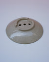Round ceramic object with three holes on a white background. Soap Dish, Cara Guthrie Ceramics. Fodder