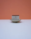 Bar of soap on a white plate with 'WS & Co' packaging against an orange background. Cara Guthrie Ceramics. Fodder