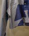 A close-up of a long-sleeve button-up shirt with an abstract geometric pattern in shades of blue, navy, and light gray, featuring light-colored buttons. Caroline Dickinson Shirt | Fodder
