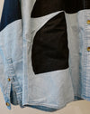 A close-up of a denim patchwork shirt featuring light blue, dark blue, and black fabric panels, with gold-tone buttons. Caroline Dickinson Shirt | Fodder