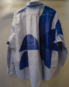 A light blue chambray button-down shirt with a bold blue geometric block print pattern, shown from the back on a mannequin against a neutral beige background. Caroline Dickinson Shirt | Fodder