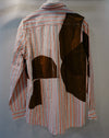 A striped long-sleeve shirt with abstract brown patchwork overlays, displayed on a mannequin against a neutral gray background. Caroline Dickinson Shirt | Fodder