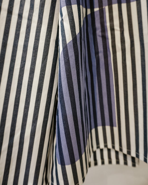A close-up of a striped fabric with vertical black and white stripes on the left and a geometric pattern on the right featuring black, white, and muted purple-blue blocks. Caroline Dickinson Shirt | Fodder