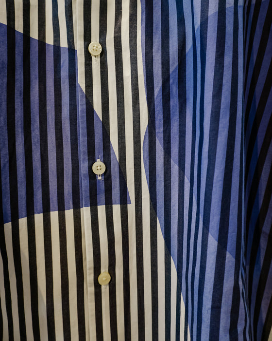 Close-up of a button-front shirt with vertical navy, black, and off-white stripes, overlaid with abstract blue and navy graphic shapes. Caroline Dickinson Shirt | Fodder