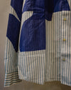A close-up of a long-sleeve button-up shirt with a patchwork design combining blue solid panels and light blue and white vertical stripes. Caroline Dickinson Shirt | Fodder