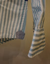 Close-up of a striped garment, likely a shirt or dress, with vertical and horizontal blue, white, and light gray stripes, featuring a small blue fabric patch near the hem and a striped cuff. Caroline Dickinson Shirt | Fodder