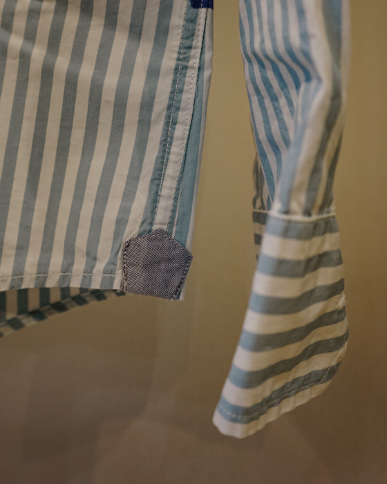 Close-up of a striped garment, likely a shirt or dress, with vertical and horizontal blue, white, and light gray stripes, featuring a small blue fabric patch near the hem and a striped cuff. Caroline Dickinson Shirt | Fodder