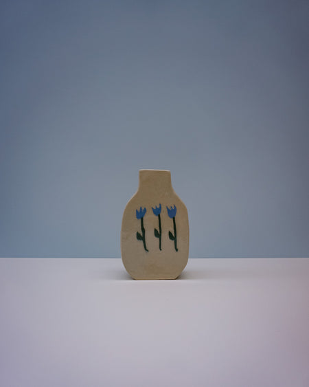Small beige vase with blue floral design on a light gray background | Tulip Vase | Nerikomi | Fern Taylor | Shop Fodder